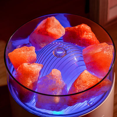 White cool-mist humidifier and aroma diffuser with glowing blue LED lights and orange crystal salt rocks, emitting mist. - Image 11