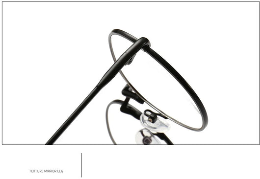 Black round anti-blue light glasses with clear lenses showing a blue reflection, resting on a gray textured surface. - Image 15