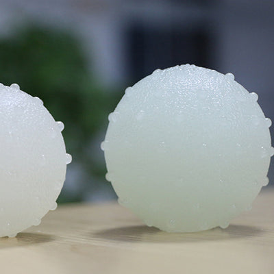 Interactive pet glow ball, off-white in daylight and glowing green in the evening, with a textured surface. - Image 4