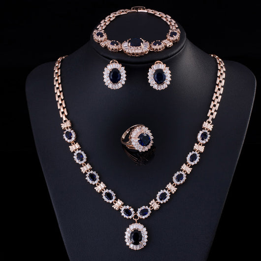 Rose gold tone jewelry set with oval blue gemstones and clear accents, including a necklace, bracelet, earrings, and ring. - Image 11