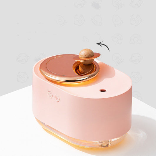 Dark green and rose gold rotating planet humidifier with a clear water tank and a wooden planet-like top. - Image 10