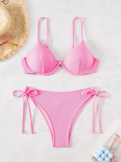 Black ribbed two-piece bikini with an underwire top and tie-side bottoms on a white marble surface. - Image 24