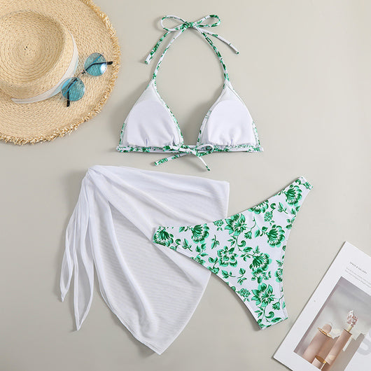 White and yellow floral print three-piece bikini set with a halter triangle top, high-cut bottom, and sheer white sarong. - Image 32