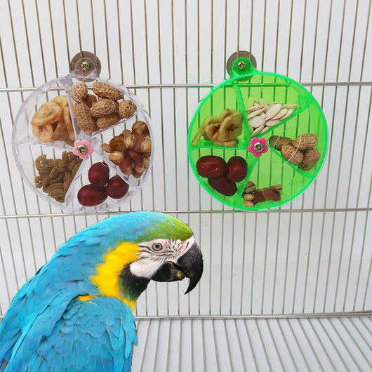 Clear acrylic bird foraging wind wheel toy with multiple compartments filled with nuts and dried fruit, attached to a bird cage. - Image 8