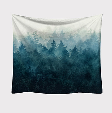 Rectangular tapestry featuring a misty forest print with a gradient of deep blue and green trees against a light background.