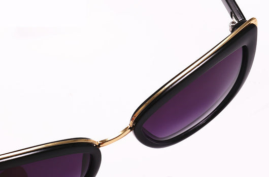 Black cat-eye sunglasses for women with gradient grey lenses and subtle gold-tone metal accents on the frame. - Image 4