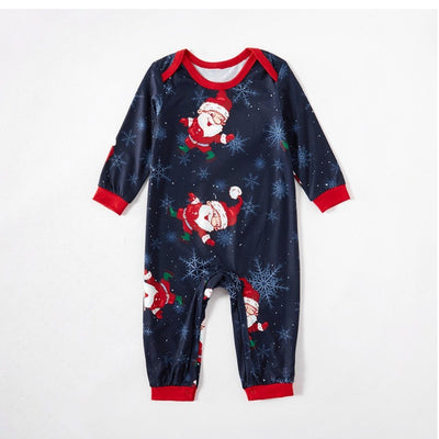 Family of four wearing matching navy blue Christmas pajamas with Santa Claus and snowflake print, red trim. - Image 5