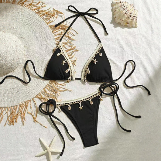 Light pink ribbed halterneck bikini with triangle cups and tie-side bottom, adorned with shell and starfish charms.