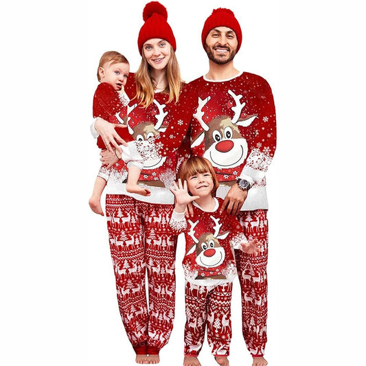 Family of four wearing matching red Christmas pajamas with reindeer and snowflake patterns and red pom-pom beanies. - Image 2