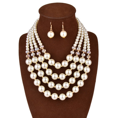 Multi-strand faux pearl and crystal necklace with matching drop earrings on a black jewelry bust.