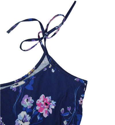 Woman wearing a navy blue floral wide-leg jumpsuit with pink and white flowers, tie-shoulder straps, and a drawstring waist. - Image 4