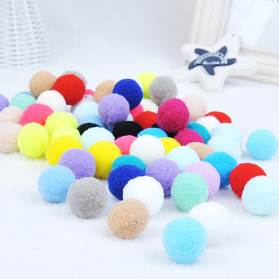Assortment of colorful plush pom-pom balls, some in a wooden box, others scattered on a white surface. - Image 9