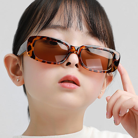 Children's small frame oval sunglasses with a solid white PC frame and brown AC lenses for UV protection. - Image 15