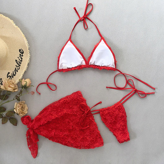 Red three-piece bikini set with a halter top, tie-side thong bottom, and sarong, all featuring a raised floral pattern. - Image 21