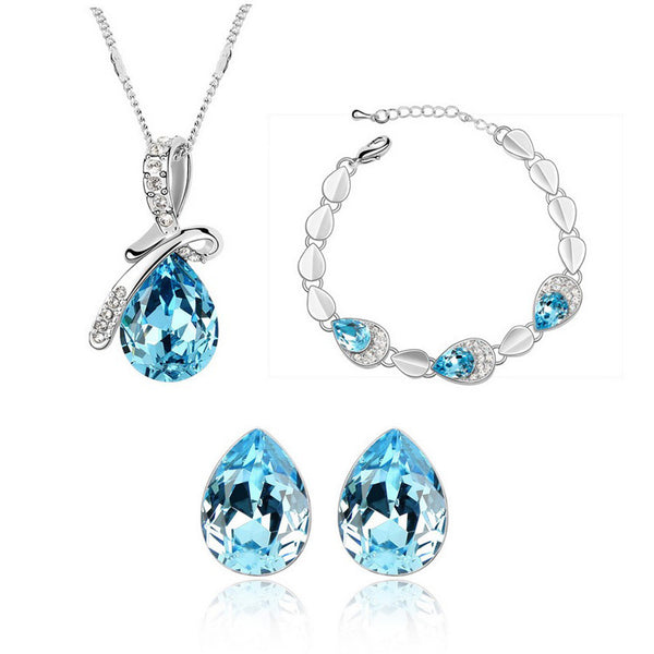 Pink teardrop crystal jewelry set with silver-tone necklace, bracelet, and stud earrings, accented with clear stones.