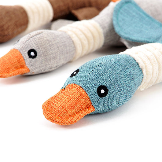 Plush teal duck dog toy with orange beak and feet, and a white ribbed neck, designed for sounding and puzzling. - Image 3