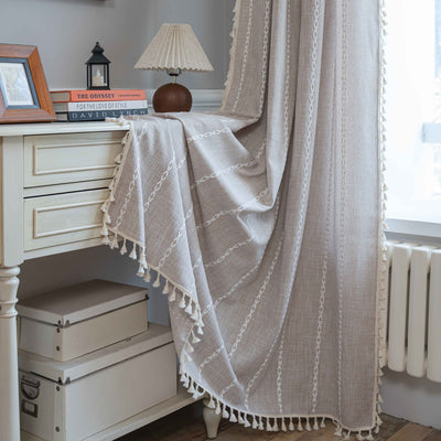 Black polyester curtain with white jacquard multi-line pattern and black tassels, draped over a white chair. - Image 12