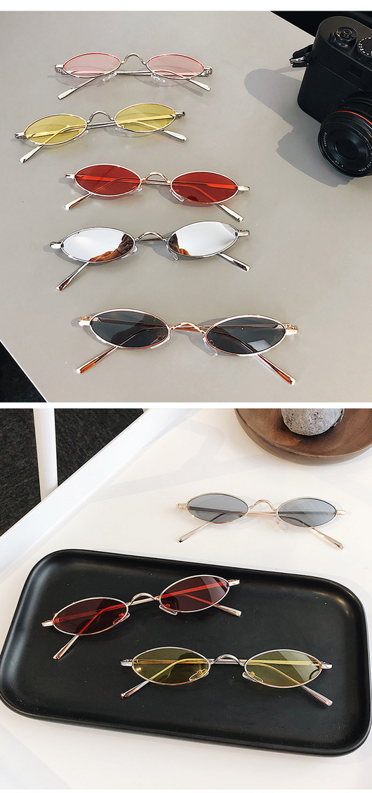 Silver-framed oval sunglasses with dark lenses reflecting a warm-toned object, displayed on a white tray. - Image 9