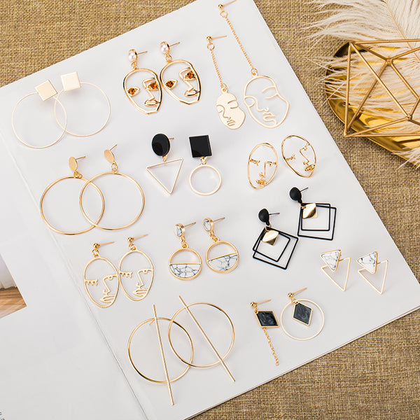 Pair of silver geometric round hoop earrings with a small circular stud and thin, large hoops.