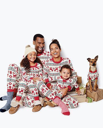 Family of four and a dog wearing matching long-sleeved Christmas pajamas with red reindeer and green snowflake print. - Image 7
