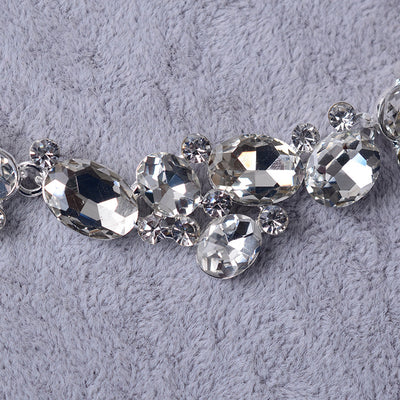 Silver-tone bridal necklace and matching drop earrings set with clear oval and round rhinestones, displayed on a gray velvet stand. - Image 3