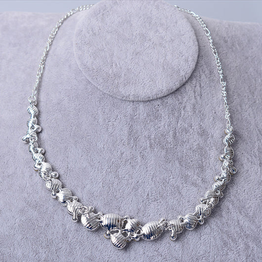 Silver-tone bridal necklace and matching drop earrings set with clear oval and round rhinestones, displayed on a gray velvet stand. - Image 4