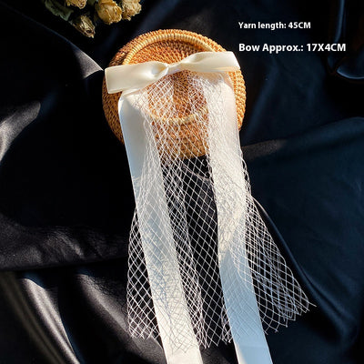 White birdcage veil with a cream satin bow and faux pearls, attached to a woven straw base, 80cm yarn length. - Image 16