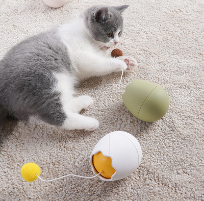 White egg-shaped automatic cat toy with a yellow interior and a flexible wire holding a yellow fuzzy ball. - Image 4