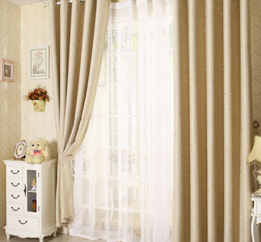 Blue star print curtains tied back to reveal sheer white curtains, in a bright room with a white chair. - Image 12