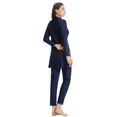 Woman in a navy blue quick-drying conservative swimwear set with a tropical leaf print tunic and matching swim cap. - Image 14
