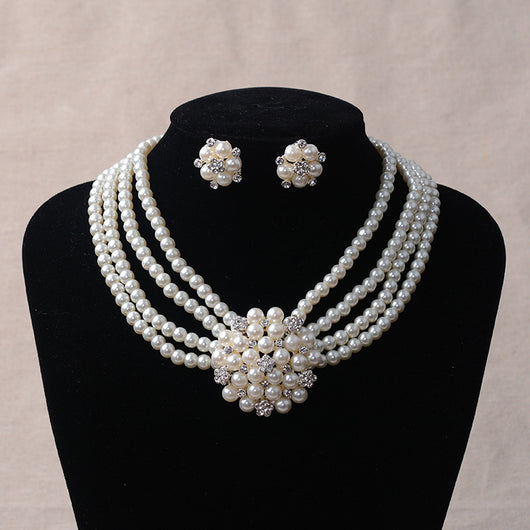 Luxury bridal pearl necklace and earring set with a multi-strand design and rhinestone flower accent.