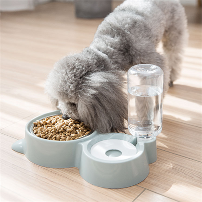 White pet feeding station with a stainless steel food bowl and a clear automatic water dispenser bottle.
