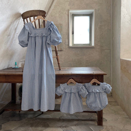 Light blue and white gingham baby romper with puff sleeves and ruffled square neckline, hanging on a wooden chair. - Image 9