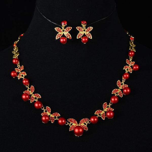 Red pearl and rhinestone necklace and earrings set with gold-toned clover designs, perfect for a wedding or special occasion. - Image 5