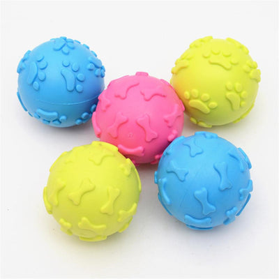 Five colorful TPR rubber pet toy balls in blue, pink, and yellow, with embossed paw print and bone patterns.