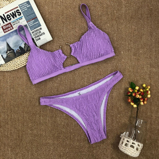 Red pleated cutout bikini set with a triangle top and thong bottom, displayed with yellow sunglasses and white flowers. - Image 3