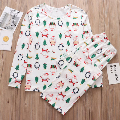 Family of four wearing matching white Christmas pajamas with Santa, penguin, reindeer, and tree print. - Image 4