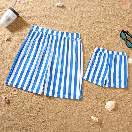 Blue and white striped one-piece swimsuit with a bow detail on the bust, laid on sand with sunglasses. - Image 5