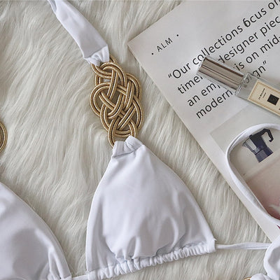 White two-piece bikini with gold braided knot details on the halter straps and tie-side bottom, laid flat. - Image 4