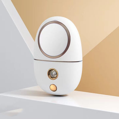 White egg-shaped portable facial humidifier with a pink cartoon rabbit inside a clear dome, gold nozzle and button. - Image 20