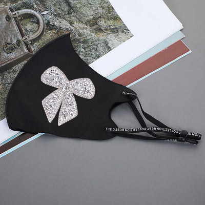 Black ear-mounted mask with a sparkling rhinestone bow pattern, featuring adjustable ear loops. - Image 21