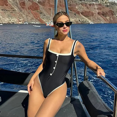Woman in a white one-piece swimsuit with black trim and decorative buttons, sitting on a boat. - Image 10
