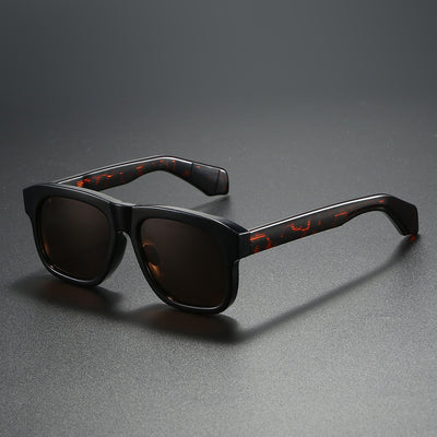 Black square-frame polarized sunglasses with dark lenses, suitable for both men and women, on a dark gray surface. - Image 3