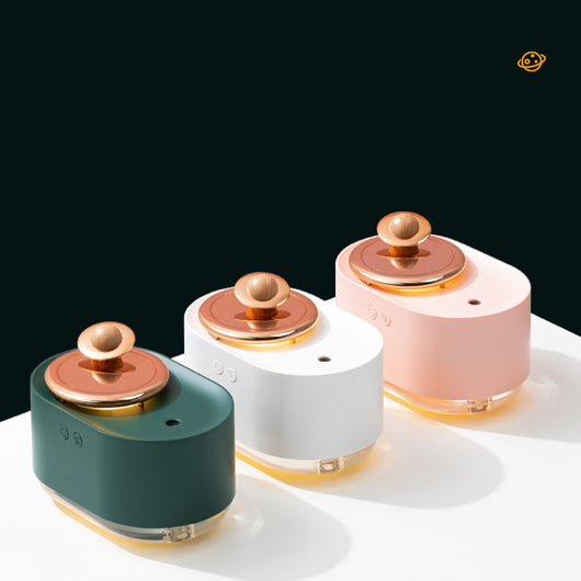 Dark green and rose gold rotating planet humidifier with a clear water tank and a wooden planet-like top. - Image 4
