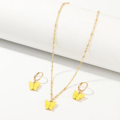 Blue resin butterfly necklace and earring set with gold-tone chains and findings, displayed on a light background. - Image 4