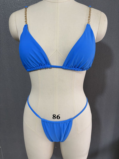 White three-point bikini with gold chain straps on a mannequin, featuring a triangle top and thong bottom. - Image 27