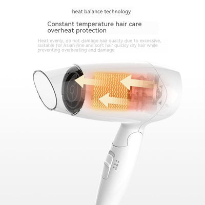 White compact hair dryer with a clear nozzle and control buttons on the handle, ideal for household or travel use. - Image 2
