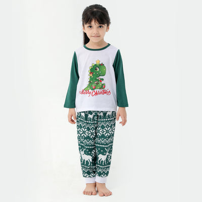 Woman in a Christmas pajama set with a white top, green sleeves, dinosaur graphic, and green fair isle pants. - Image 30