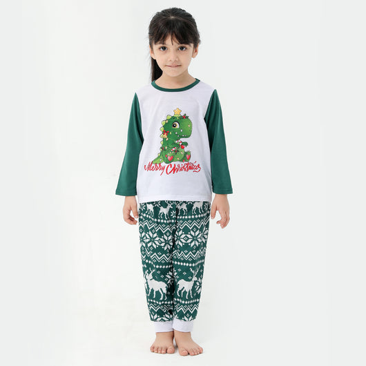 Woman in a Christmas pajama set with a white top, green sleeves, dinosaur graphic, and green fair isle pants. - Image 30