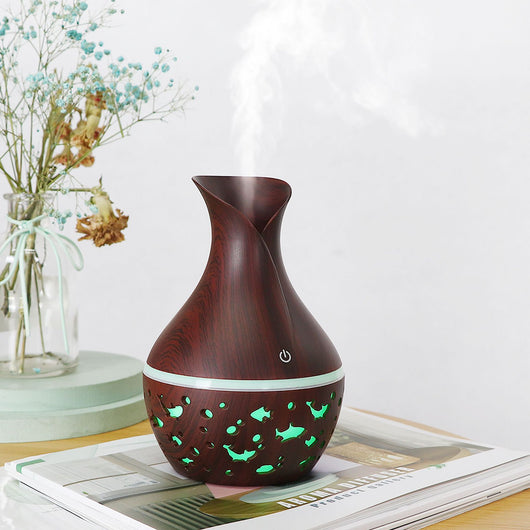 Dark wood grain humidifier shaped like a vase, with glowing green animal cutouts and mist emitting from the top. - Image 8